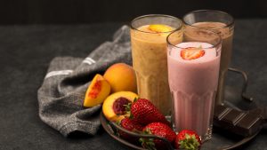 Assortment of milkshake glasses with fruits and chocolate
